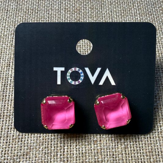 Pink square earrings on a Tova branded card against a textured beige background